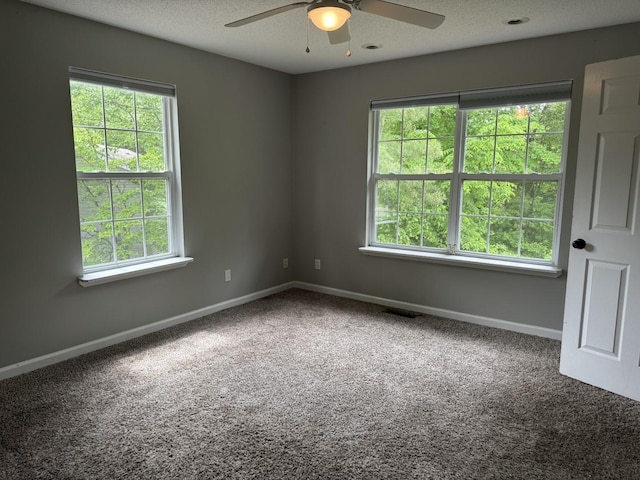 unfurnished room with ceiling fan, carpet floors, baseboards, and a textured ceiling