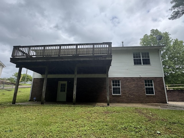 rear view of property with a lawn, brick siding, and a wooden deck