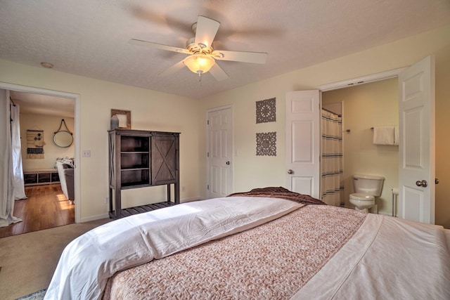 carpeted bedroom featuring ensuite bath, baseboards, and ceiling fan