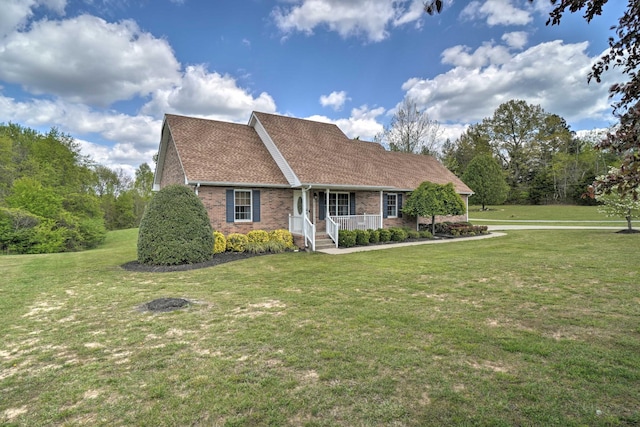 view of front of house with a porch, brick siding, and a front yard