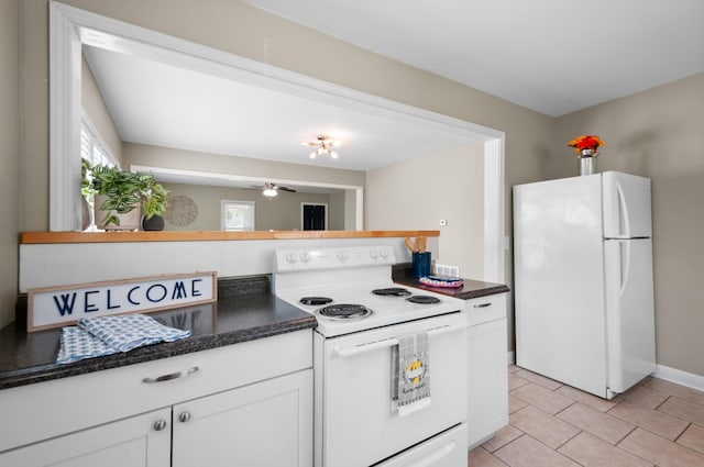 407 High St, Dickson, TN 37055 - kitchen with white appliances, white cabinets, light tile patterned floors, ceiling fan, and dark stone countertops