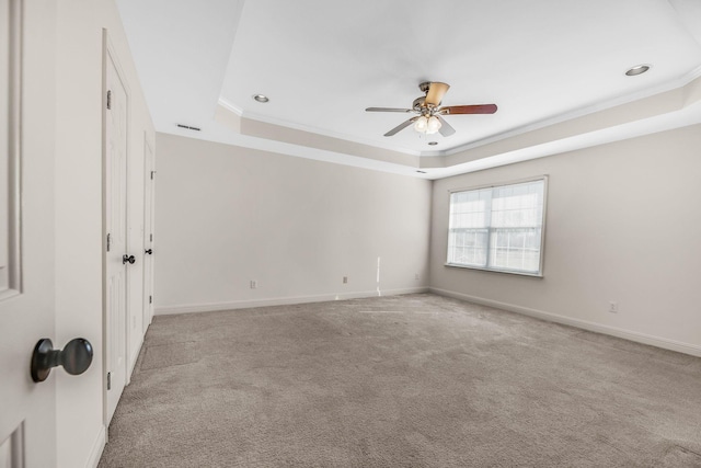 carpeted empty room featuring a raised ceiling, a ceiling fan, ornamental molding, baseboards, and recessed lighting