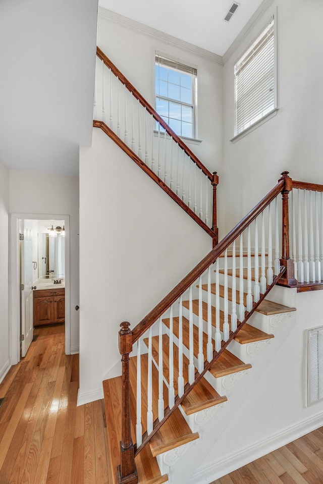 stairs with hardwood / wood-style flooring, ornamental molding, and baseboards