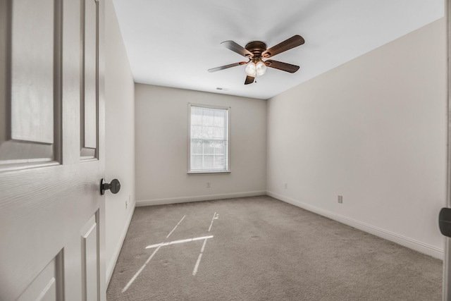 empty room featuring carpet floors, a ceiling fan, and baseboards