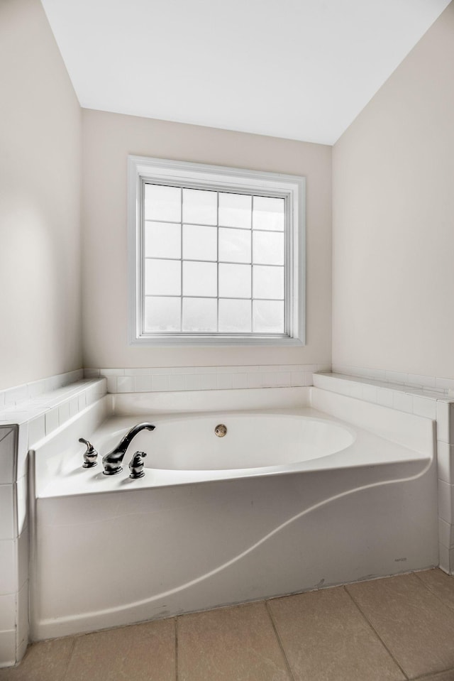 bathroom with a bath and tile patterned flooring