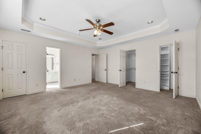 unfurnished bedroom featuring a raised ceiling, ornamental molding, carpet, baseboards, and recessed lighting