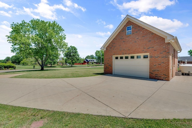 view of home's exterior with a yard, brick siding, and concrete driveway