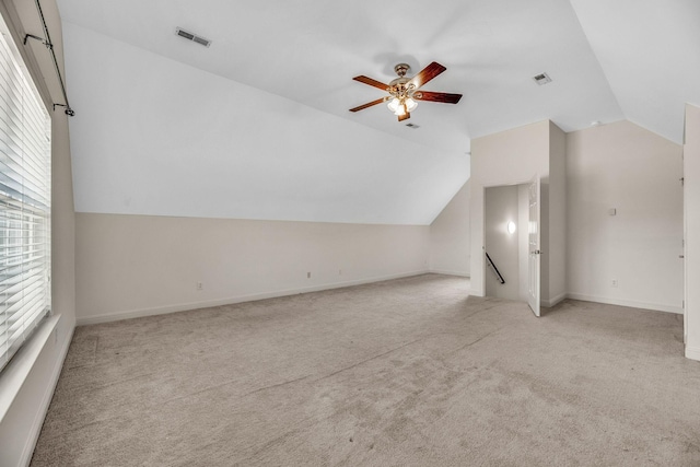 bonus room featuring vaulted ceiling, light colored carpet, ceiling fan, and baseboards