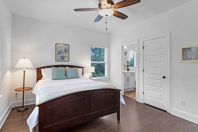 bedroom with dark wood-style flooring, connected bathroom, baseboards, and a ceiling fan