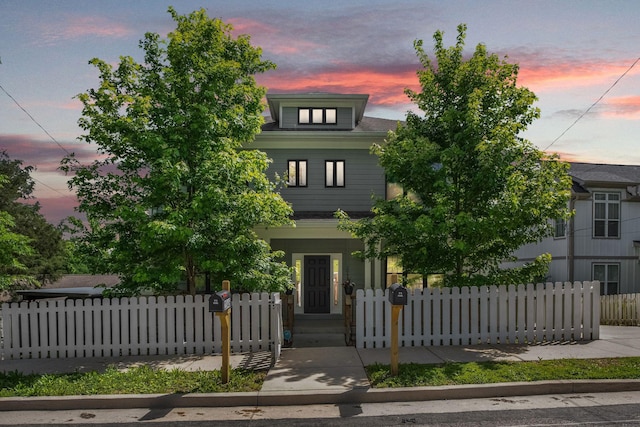 american foursquare style home featuring a fenced front yard