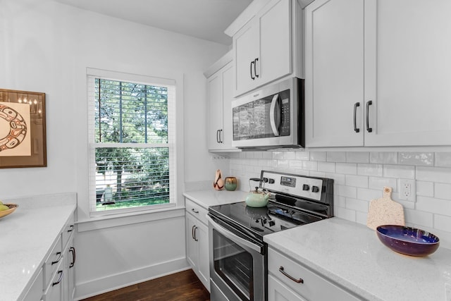 kitchen featuring stainless steel appliances, plenty of natural light, dark wood-style floors, and decorative backsplash