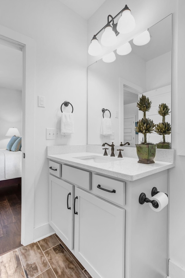 ensuite bathroom with wood finished floors and vanity