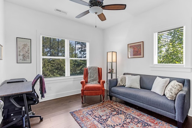 home office featuring healthy amount of natural light, wood finished floors, ceiling fan, and baseboards