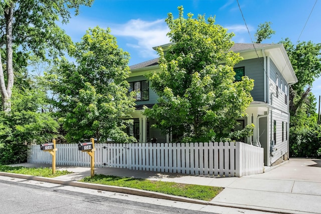 view of property hidden behind natural elements featuring a fenced front yard