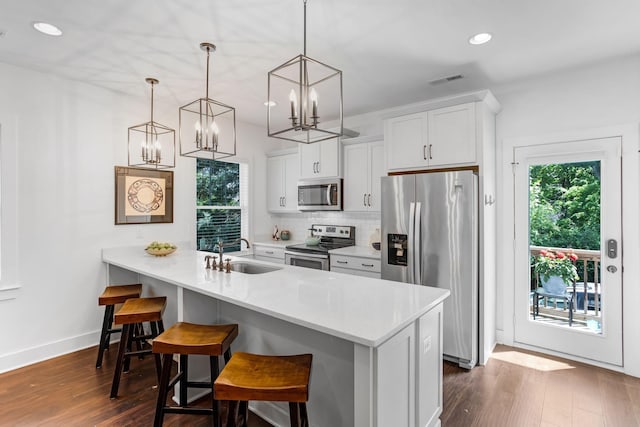 kitchen with stainless steel appliances, a sink, healthy amount of natural light, a breakfast bar, and recessed lighting