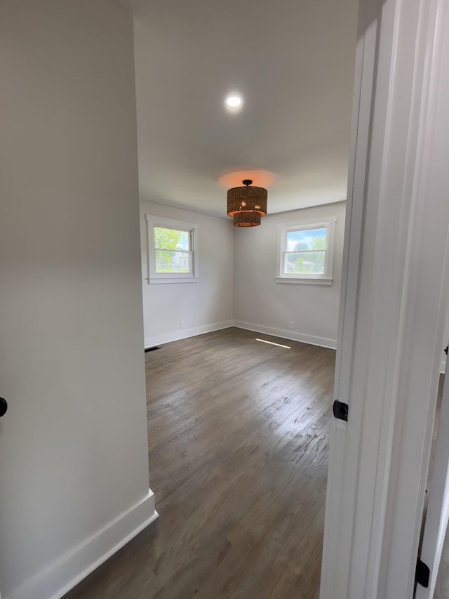 spare room with baseboards, dark wood-style floors, and recessed lighting