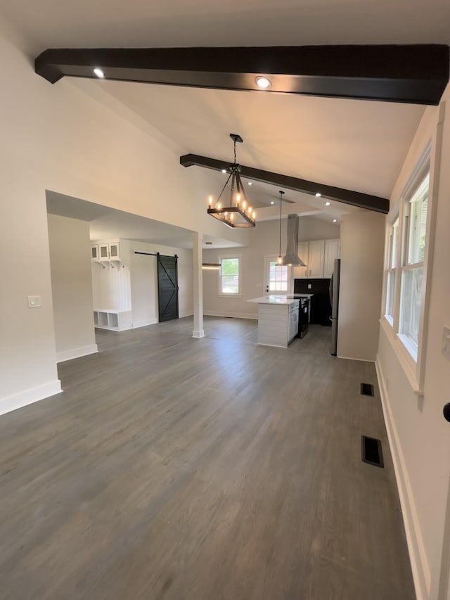 unfurnished living room with a barn door, baseboards, wood finished floors, and recessed lighting