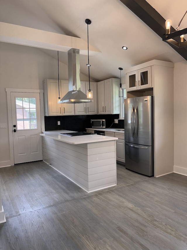kitchen featuring appliances with stainless steel finishes, island range hood, lofted ceiling, backsplash, and wood finished floors