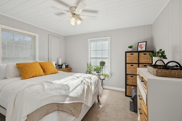 bedroom featuring multiple windows, light colored carpet, baseboards, and ceiling fan