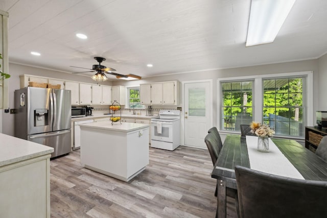 kitchen featuring stainless steel appliances, recessed lighting, light countertops, ornamental molding, and a kitchen island