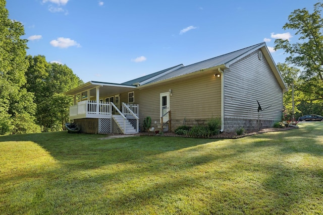 back of house with a yard, stairway, metal roof, and a porch