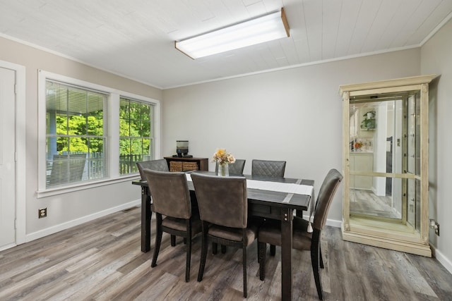 dining area featuring ornamental molding, wood finished floors, and baseboards