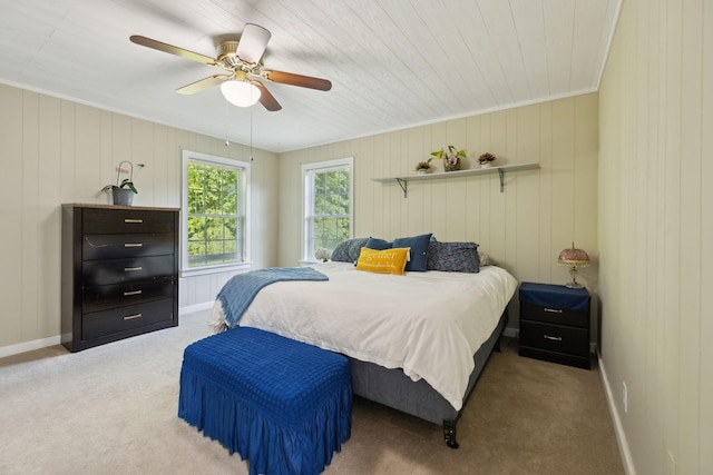 carpeted bedroom with baseboards, a ceiling fan, and ornamental molding