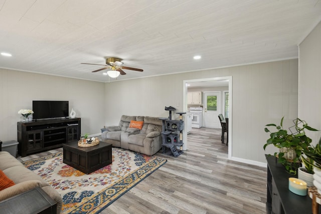 living area with light wood finished floors, crown molding, ceiling fan, recessed lighting, and baseboards