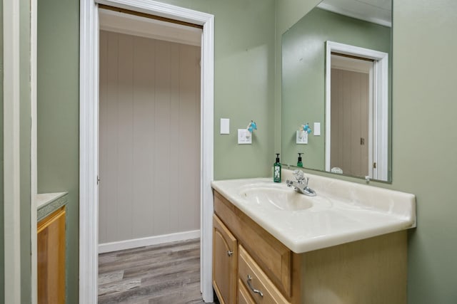 bathroom with wood finished floors, vanity, and baseboards