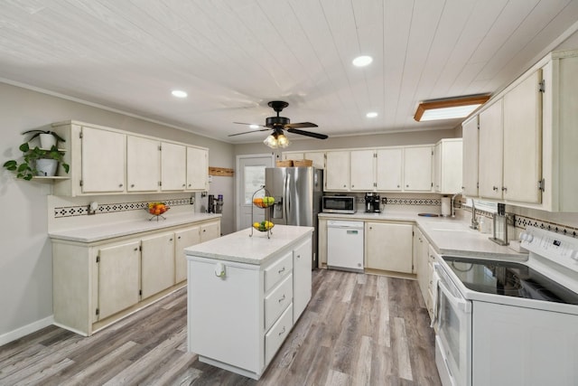 kitchen with stainless steel appliances, recessed lighting, light countertops, a center island, and light wood-type flooring