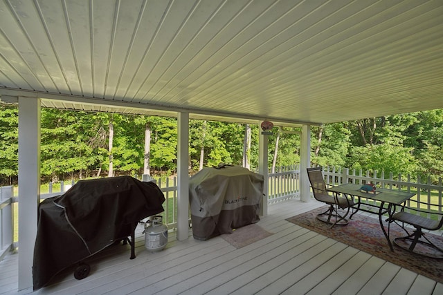 wooden terrace featuring a grill and outdoor dining space
