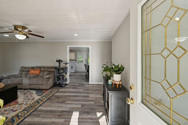 living room with wood finished floors, crown molding, a ceiling fan, recessed lighting, and baseboards