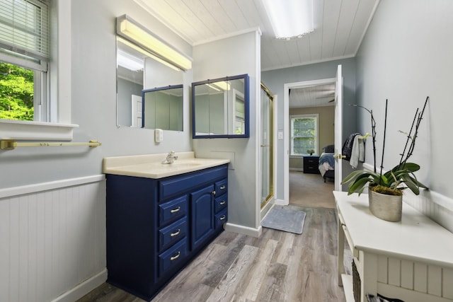 ensuite bathroom with wood finished floors, a stall shower, and vanity