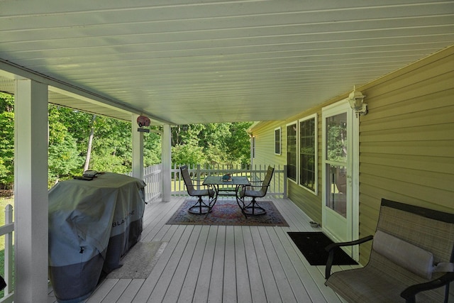 deck featuring outdoor dining space and grilling area