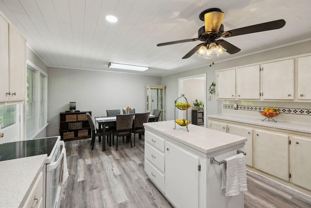 kitchen with white electric stove, a center island, ceiling fan, light wood finished floors, and recessed lighting