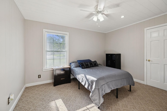 bedroom featuring light colored carpet, baseboards, crown molding, and ceiling fan