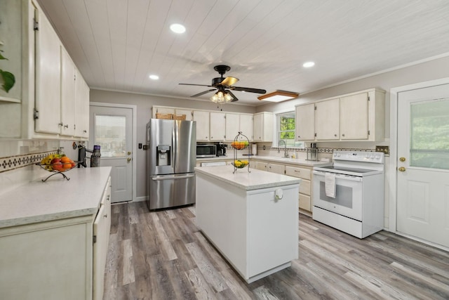 kitchen with stainless steel appliances, recessed lighting, light wood-style floors, a center island, and ceiling fan