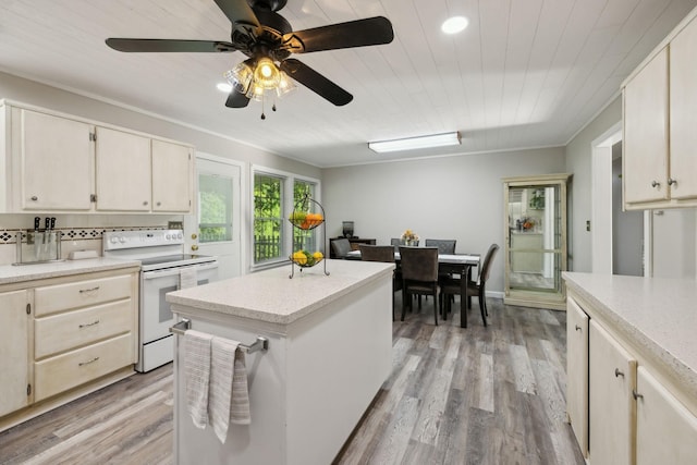 kitchen featuring white electric stove, a ceiling fan, light wood-style flooring, a kitchen island, and recessed lighting