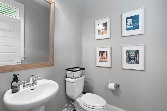 bathroom featuring a sink, toilet, and baseboards