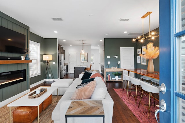 living room with dark wood-type flooring, a fireplace, and recessed lighting
