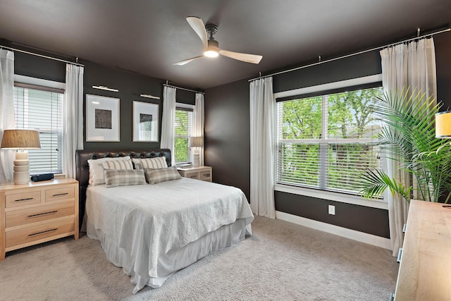 bedroom featuring light colored carpet, baseboards, and ceiling fan