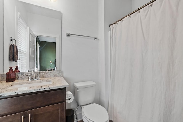 bathroom with toilet, vanity, and a shower with shower curtain