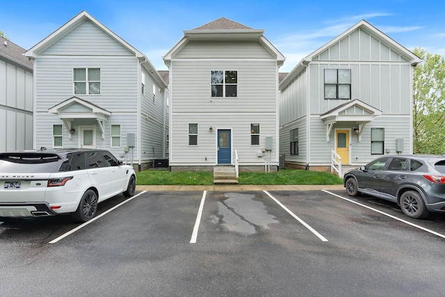 view of property with uncovered parking and entry steps