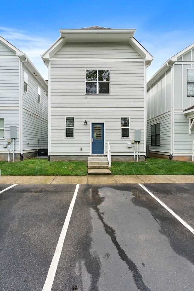 view of property featuring uncovered parking and entry steps