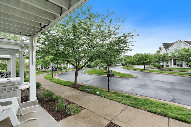 view of asphalt road with sidewalks and curbs