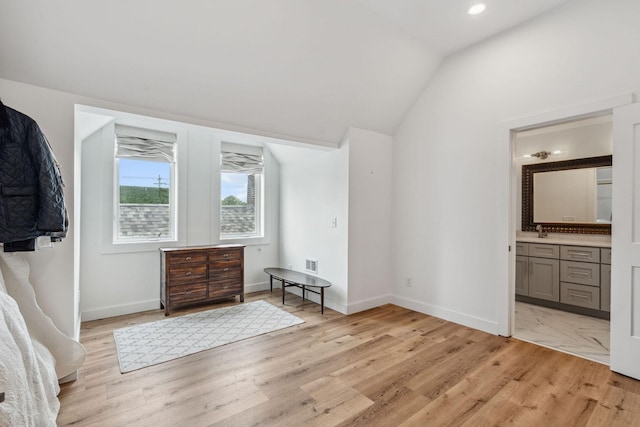 unfurnished bedroom with light wood-type flooring, lofted ceiling, baseboards, recessed lighting, and connected bathroom