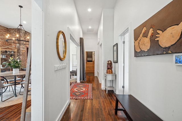 hallway with a chandelier, dark wood finished floors, baseboards, and recessed lighting