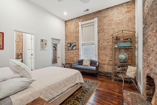 bedroom featuring brick wall, a high ceiling, recessed lighting, and wood finished floors