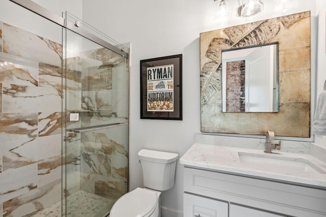 bathroom featuring a marble finish shower, toilet, and vanity