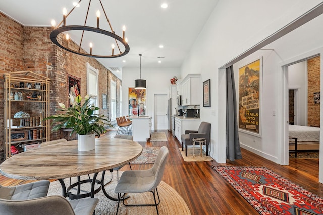 dining area featuring a chandelier, dark wood finished floors, brick wall, recessed lighting, and baseboards